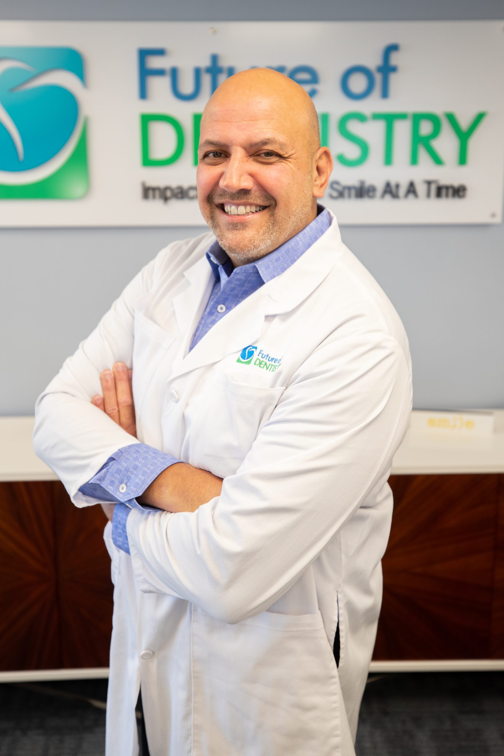 A photo of Dr. Gerry Casazza at Future of Dentistry in front of a Future of Dentistry sign