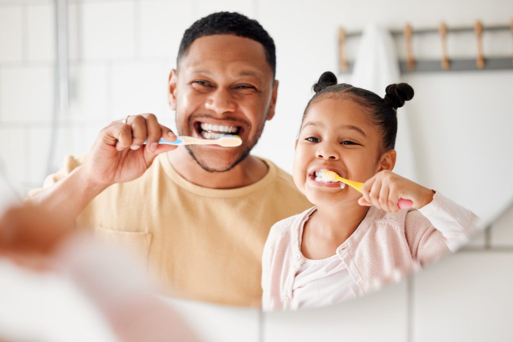 father and daughter practicing good oral health habits