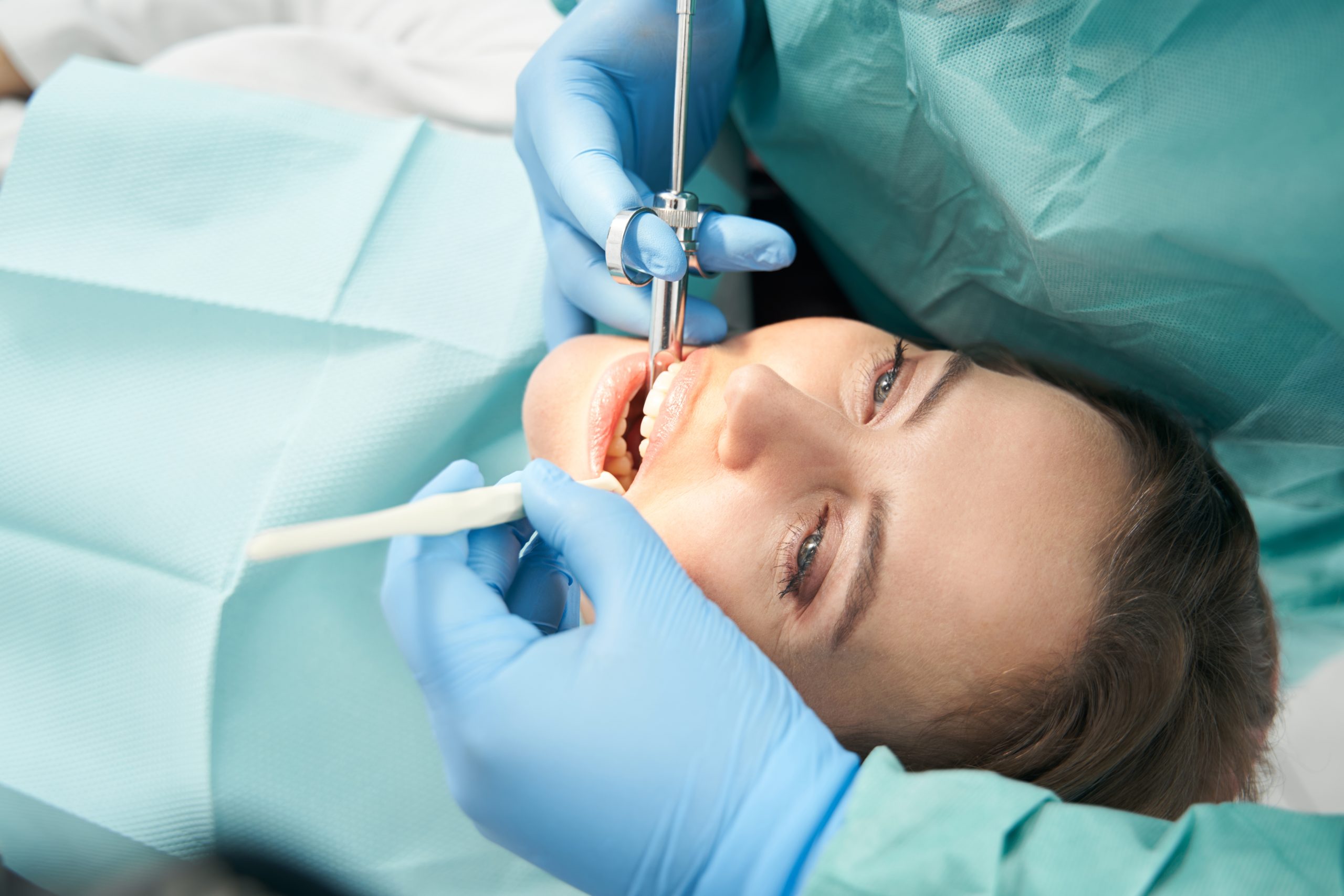 dentist in blue gloves prepping a patient for a root canal