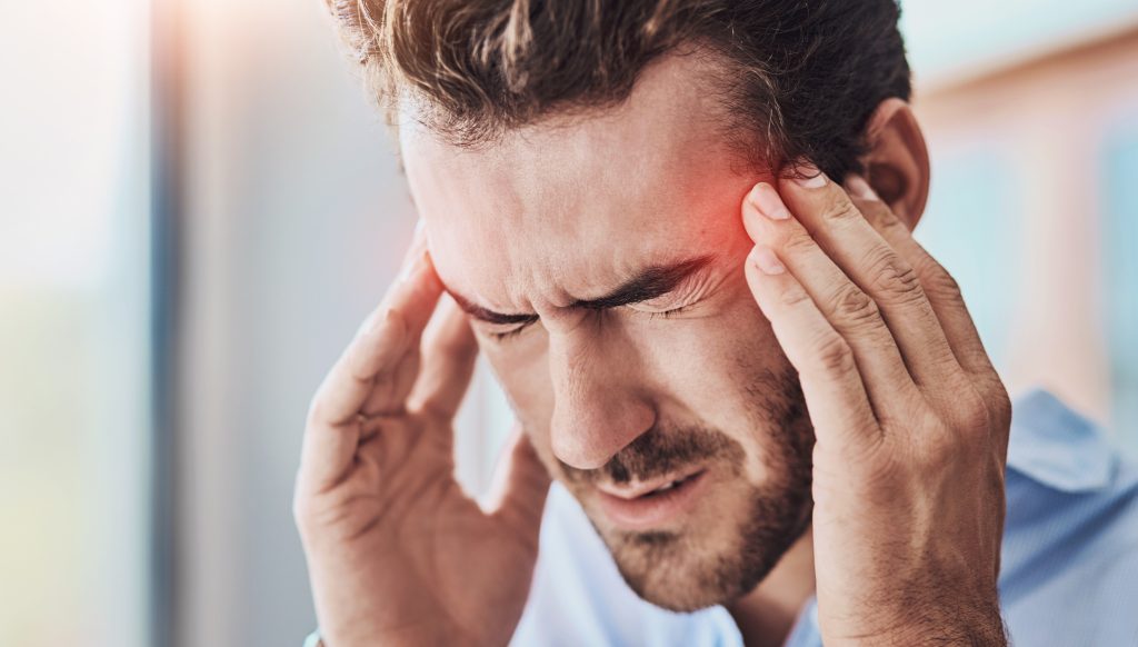 man suffering from headache and jaw pain